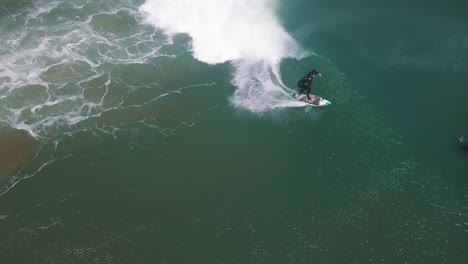 surfista profesional atrapando una ola larga en américa del sur, perú - tiro de seguimiento aéreo de drones