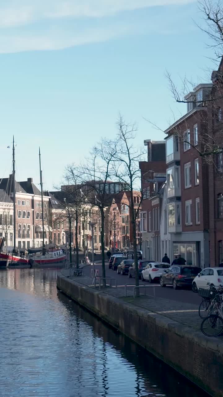 Canale in città storica europea con barche, edifici e persone
