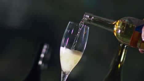 clip inclinado que vierte champán frío de una botella en una flauta de vidrio transparente