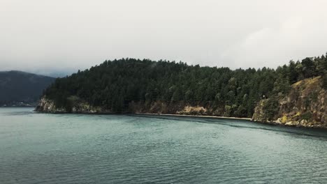 Isla-Gris-Rocosa-Cubierta-De-árboles-Verdes-En-El-Canal-Trincomali-En-Un-Día-Nublado-En-Canadá