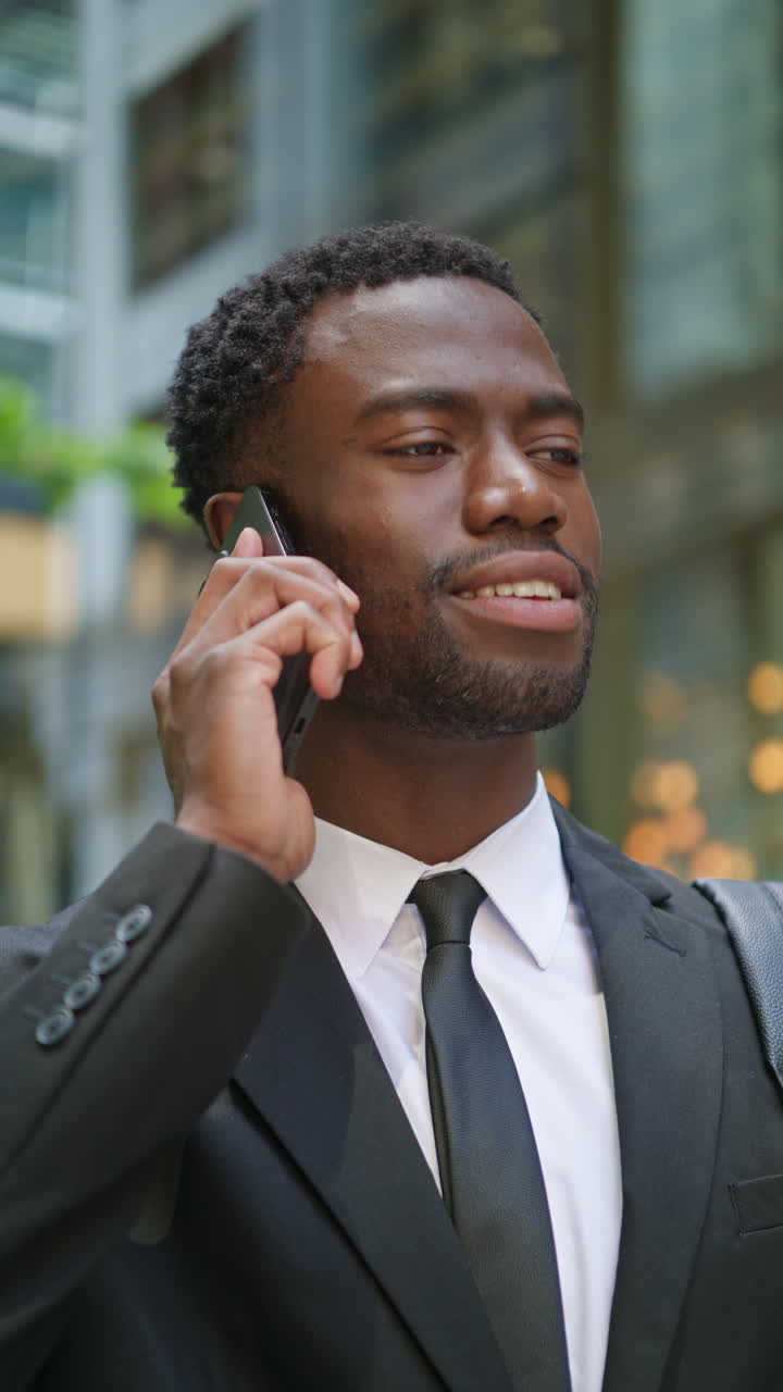 Vertical Video Shot Of Young Businessman Wearing Suit Talking On Mobile Phone Standing Outside Offices In The Financial District Of The City Of London UK Shot In Real Time