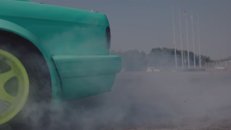 entrenamiento de conductor a la deriva en coche deportivo. coche verde hace trucos peligrosos. rueda de coche de cerca.
