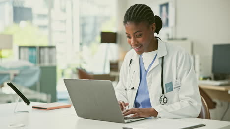 female doctor working on laptop in clinic
