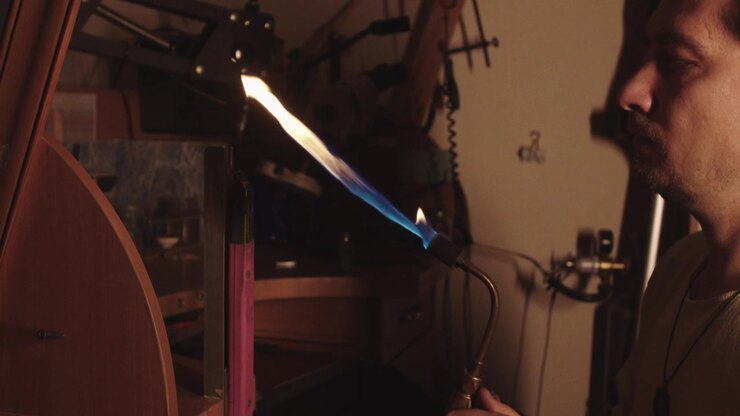 A man is working on a machine with a pink tool