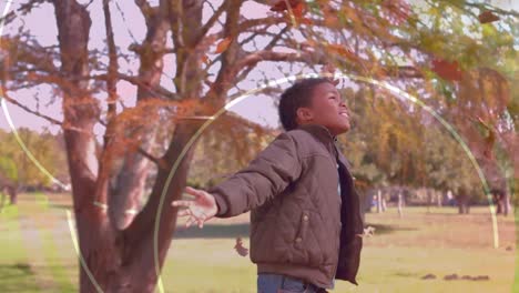 Animation-of-digital-curves-over-playful-african-american-boy-throwing-autumn-leaves-in-park