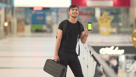 joven mostrando teléfono clave de croma y sonriendo
