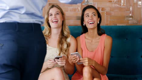 dos mujeres felices siendo servidas una copa de cóctel