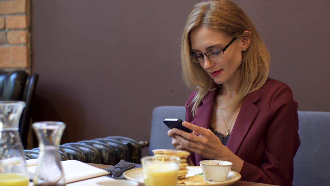 una mujer de negocios usando un teléfono inteligente en una cafetería.