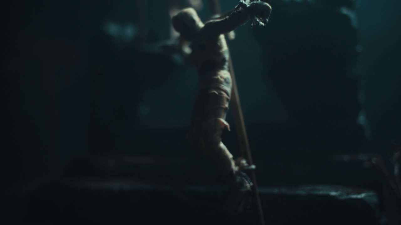 A miniature scene of the mummified dolls hanging on the gallows at night