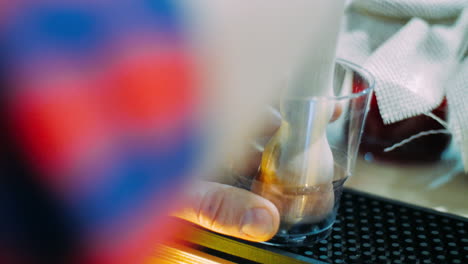 Hand-blending-berries-of-blueberries-on-bottom-of-glass.-Preparation-of-cocktail