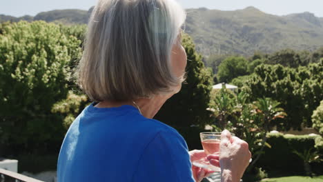 senior woman enjoying tea on balcony, admiring scenic mountain view