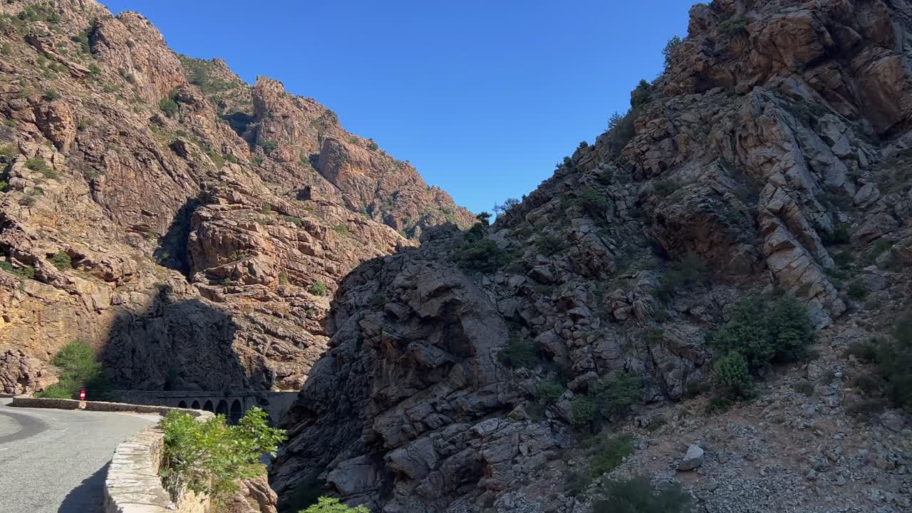 Guida POV lungo la pericolosa strada panoramica del canyon di Ruda con paesaggio montano roccioso della Corsica centrale in Francia.