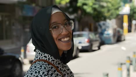 a beautiful young moroccan woman turns and smiles to camera