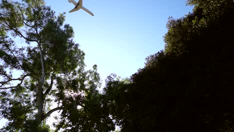 Commercial-airplane-flying-low-over-city-in-slow-motion