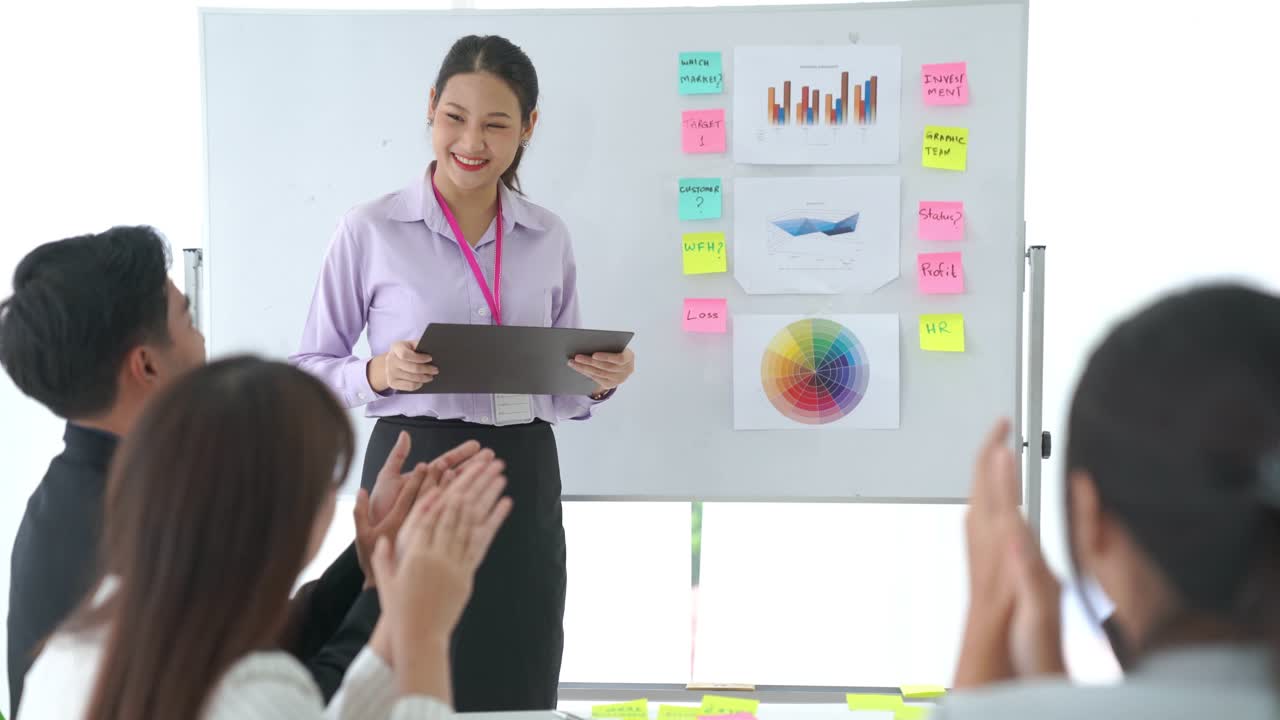 사업가 여성이 능숙하게 업무 프로젝트를 진행하고 팀으로부터 축하를 받습니다.