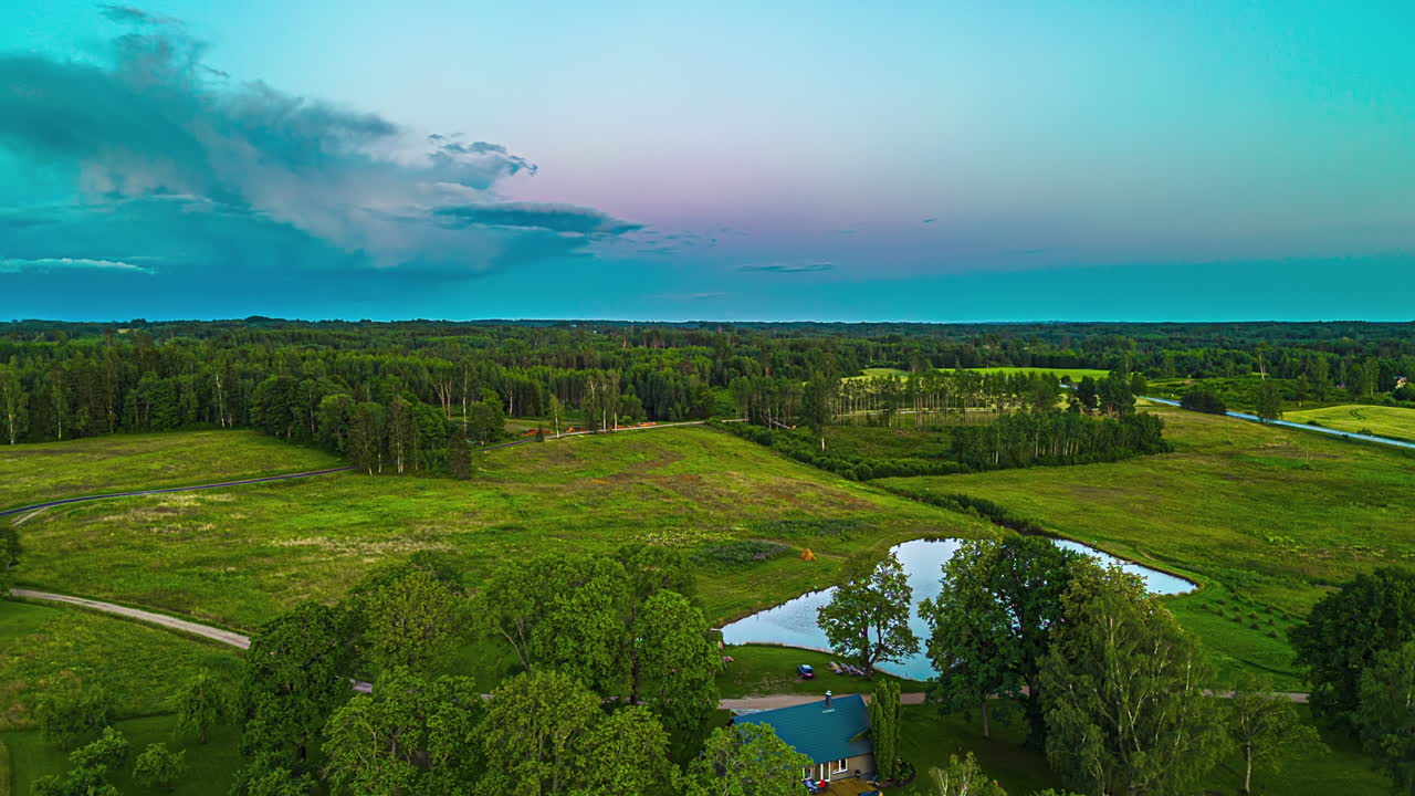 cumulonimbus 폭풍 어리는 시골 시골 에서 해가 지는 색을 반영합니다.