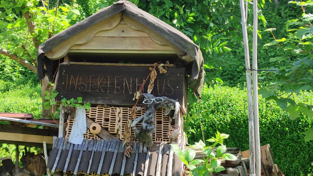 Decorative insect hotel in a green eco environment, zoom in shot. Save the bees and environmental protection concept.