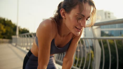 happy slightly tired sports girl pauses during her run and then continues to move. respite during morning jogging