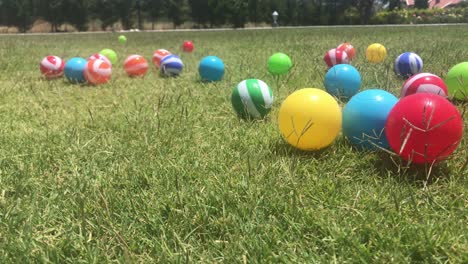 scattered plastic balls in the grass