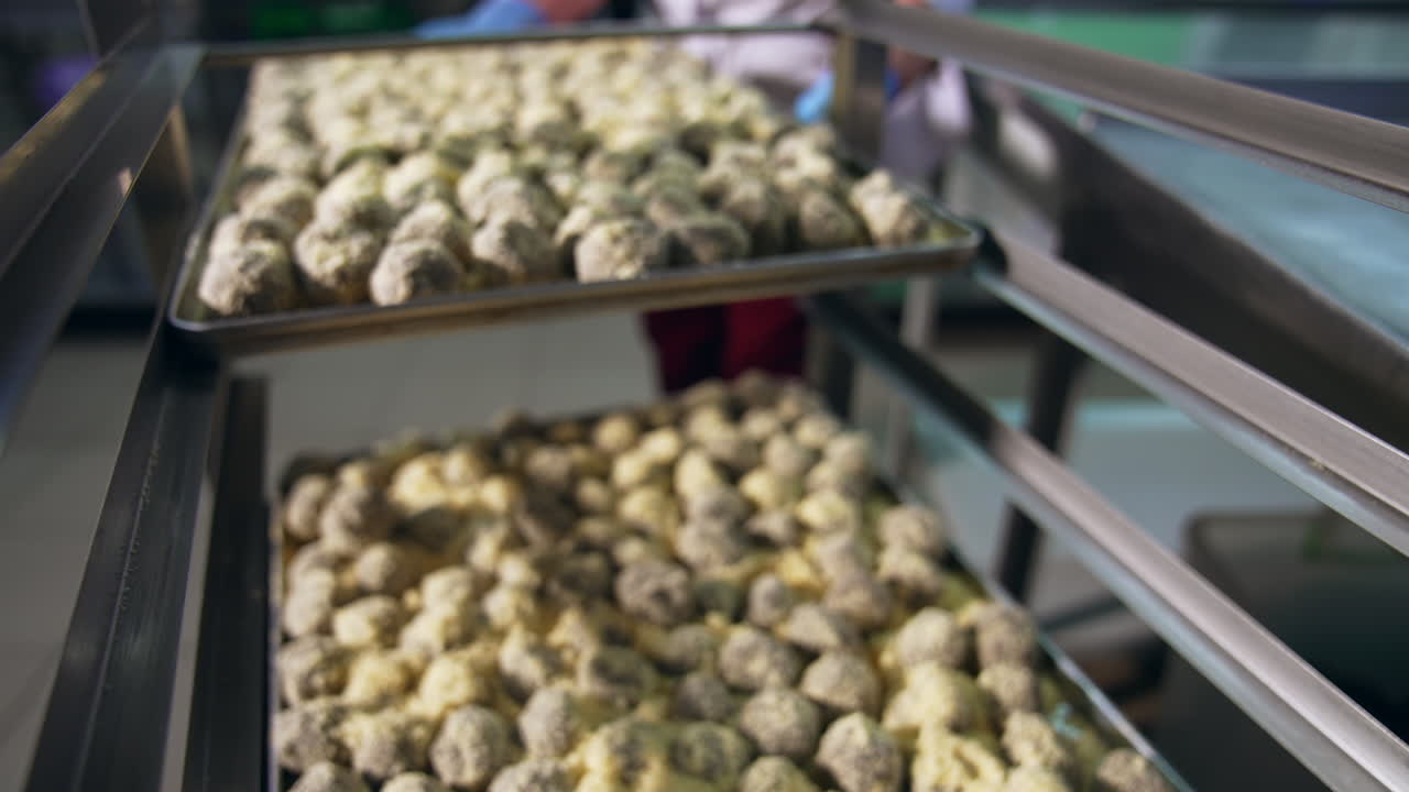 Manufacturing sweets at confectionery factory. Big tray full of freshly-made candies is put on a metal shelf. Close up.