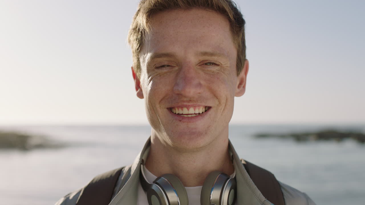 close up portrait of young attractive man laughing cheerful on beautiful sunny beach