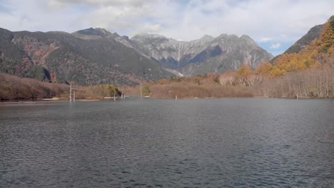 Toma-Aérea-Cinematográfica-De-Drones-Del-Vasto-Paisaje-Forestal-Kamikotchi-Durante-Los-Meses-De-Otoño-Con-Vida-De-Bosque-Naranja-Y-Agua-Azul-Clara-Y-Cielos-En-El-Día-Soleado-2