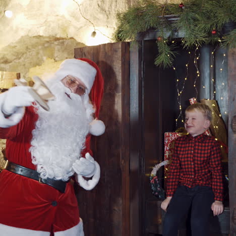 christmas time. little boy and santa claus with homemade toy plane. santa shows a happy boy how wooden plane can fly.