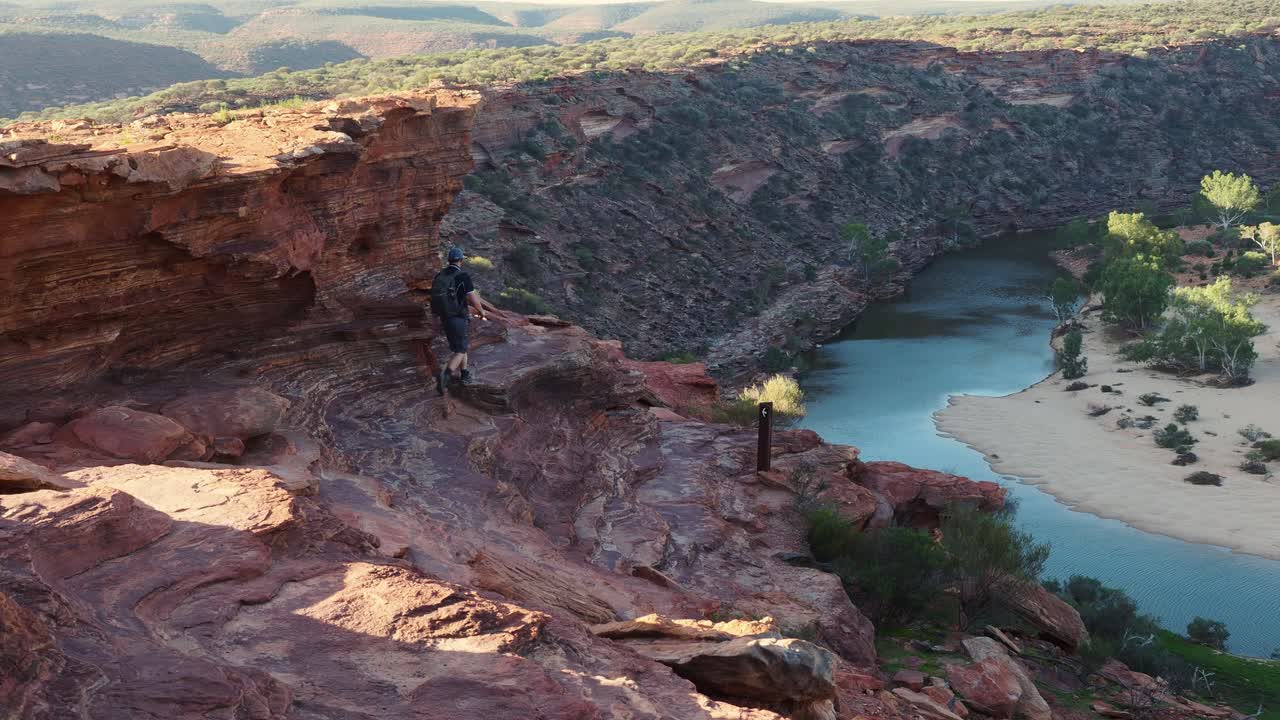 человек уходит, исчезает за охристым утесом над ущельем