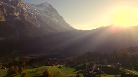 Imágenes-Aéreas-De-Drones-Subiendo-Y-Empujando-Hacia-El-Pueblo-De-Grindewald-Y-La-Cara-Norte-Del-Eiger-Bajo-La-Impresionante-Luz-Del-Atardecer