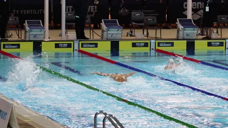 swimmers compete in a fast-paced indoor swimming race