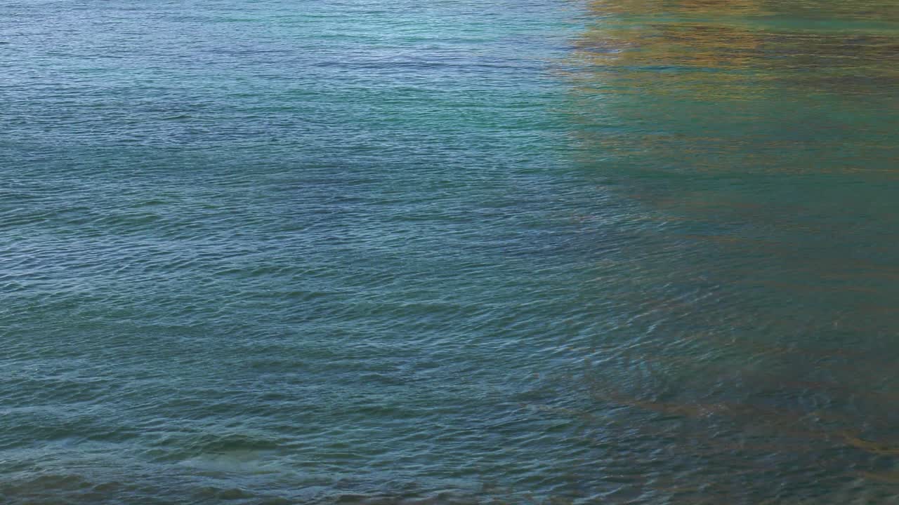 Colorful Rippled water reflecting sea cliffs, abstract