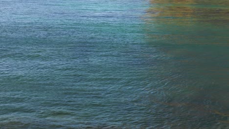 colorful rippled water reflecting sea cliffs, abstract