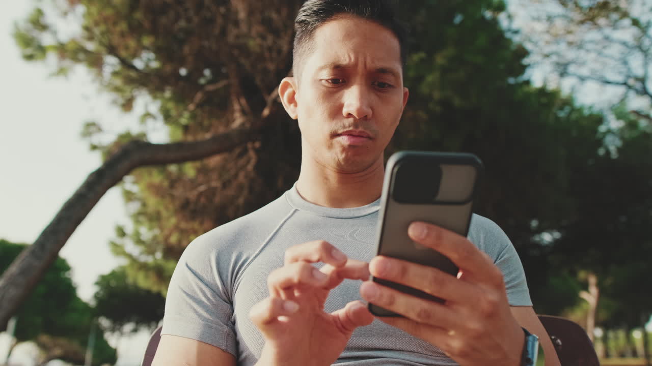 Man sitting outdoors using a mobile phone