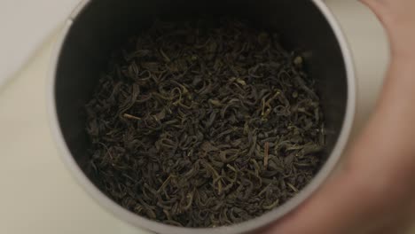 primer plano sobre el ingrediente del té verde dentro de la lata decorativa de metal