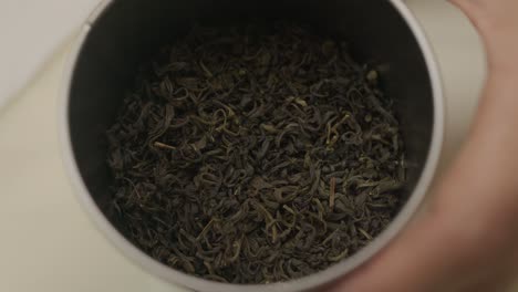 close up on green tea ingredient inside metal decorative can