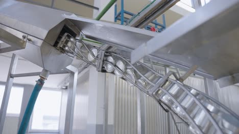 cans moving on a conveyor belt in a food production line, featuring automation, packaging, sealing, and quality control in an industrial setting