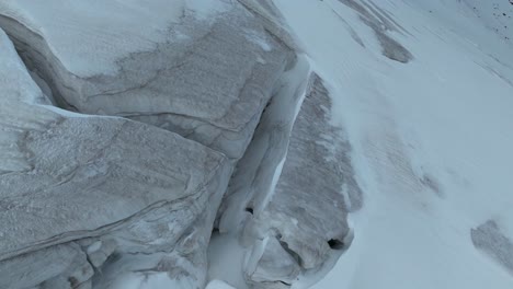 Die-Luftaufnahme-Erfasst-Komplizierte-Gletscherspalten,-Die-Sich-Durch-Einen-Gletscher-Schlängeln,-Und-Offenbart-Die-Raue-Schönheit-Und-Dynamische-Natur-Gefrorener-Gebiete