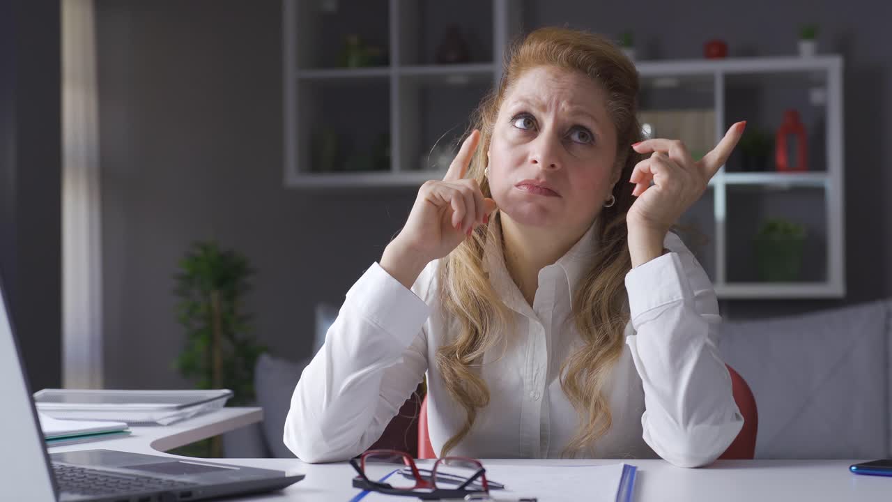 una mujer de negocios de edad avanzada que trabaja en su oficina en casa está pensando en ideas creativas.