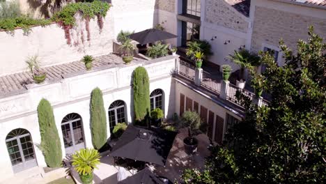 Toma-Aérea-Descendente-De-Muebles-De-Jardín-Con-Sombra-En-Un-Castillo-En-Francia.