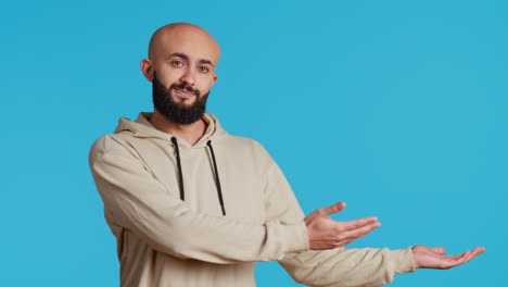 cheerful man creating ad in front of studio camera