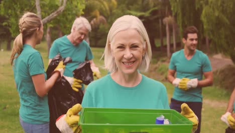 video de un grupo feliz y diverso recogiendo basura en el campo