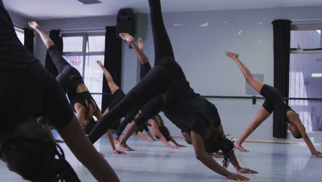 multi-ethnic group of fit male and female modern dancers practicing a dance routine