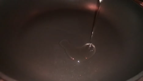 slow motion of oil being poured down a frying pan