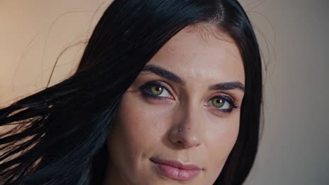 close-up portrait of a woman with long black hair and green eyes.