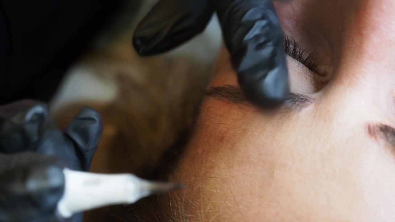 Eyebrow micropigmentation procedure on client before cosmetic tattooing with precision treatment tool
