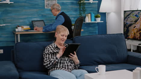 happy old senior grandmother holding digital tablet browsing informations