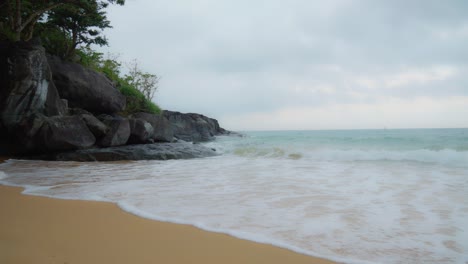 Filmaufnahme-Von-Meereswellen,-Die-Sich-An-Den-Felsen-Und-Am-Sandstrand-Der-Insel-Con-Dao-Brechen