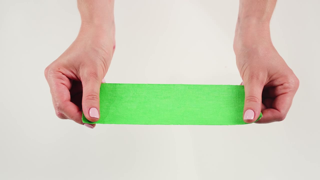 Kinesiology medical taping, doctor Physical therapist applying elastic surgical tape to patient body, treating injured knee young athlete.Post traumatic rehabilitation, sport physical therapy recovery