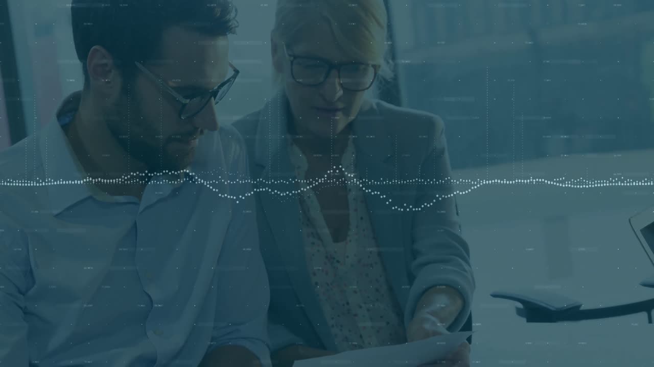Animation of data processing over two diverse businessman and businesswoman discussing at office