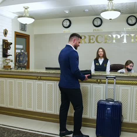 man in hotel lobby pay with nfc